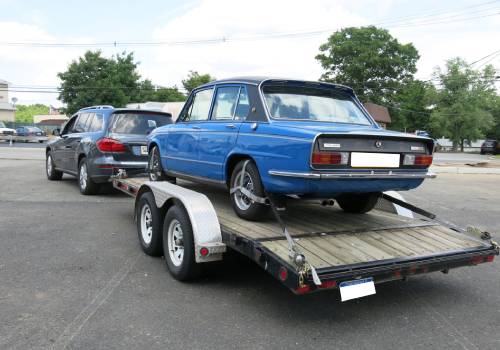 Vintage car being towed on a trailer